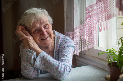 An elderly woman sitting in her home.