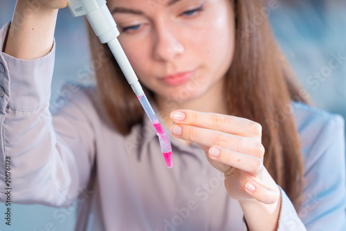 Fototapeta Naklejka Na Ścianę i Meble -  Young woman cutting of sample from pcr microtube rack