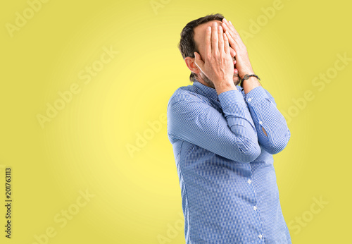 Handsome middle age man stressful keeping hands on head, tired and frustrated