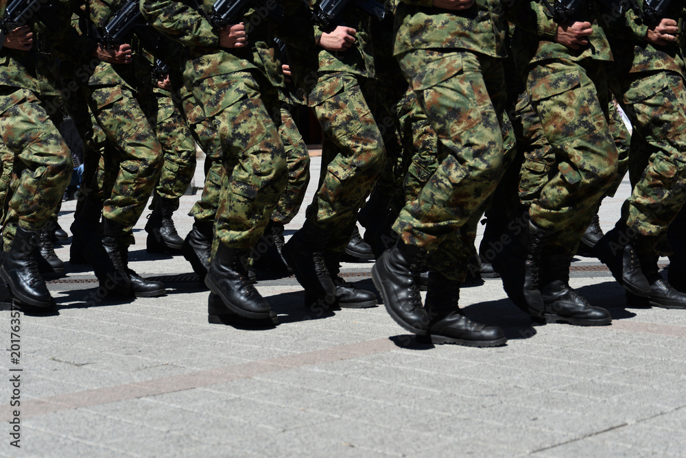 Army military soldiers marching in a parade outdoors. Army military soldiers marching in a parade outdoors.
