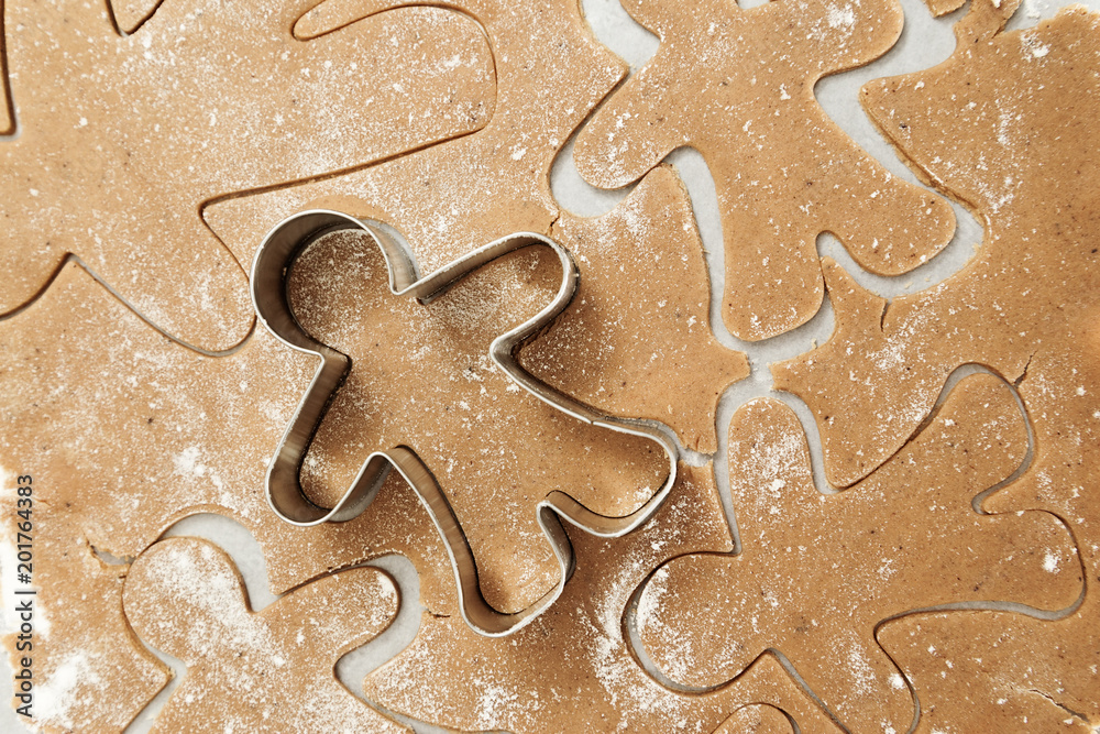 Preparation of ginger biscuits. A metal form in the form of gingerbread man for cutting figured cookies. New Year's Eve symbol. Preparation of ginger biscuits. A metal form in the form of gingerbread man for cutting figured cookies. New Year's Eve symbol.