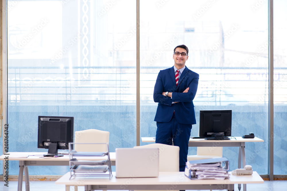 Young handsome businessman employee working in office at desk Young handsome businessman employee working in office at desk