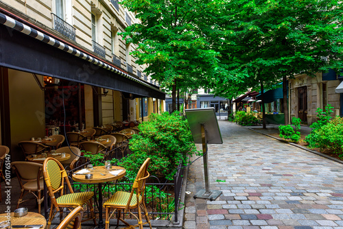 Obraz Przytulna ulica ze stolikami kawiarni w Paryżu, Francja