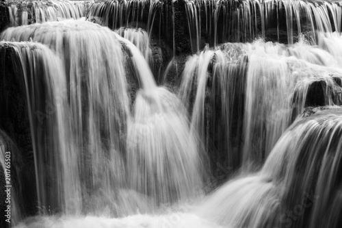 Full frame close-up of a cascade at the Tat Kuang Si Waterfalls near Luang Prabang in Laos. Natural abstract art in black and white.