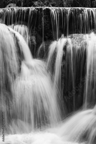 Full frame close-up of a cascade at the Tat Kuang Si Waterfalls near Luang Prabang in Laos. Natural abstract art in black and white.