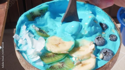 dipping spoon in blue majik superfood smoothie  bowl photo