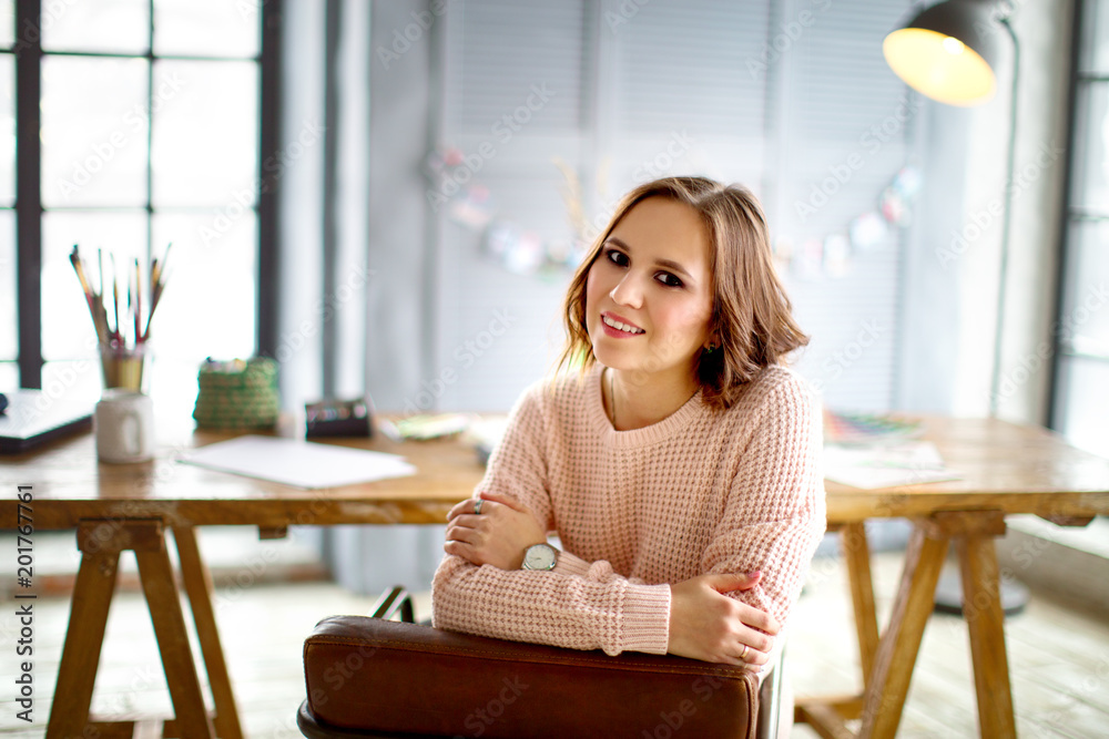 Portrait of a young female freelancer using touch screen tablet for distance job while sitting in modern interior Portrait of a young female freelancer using touch screen tablet for distance job while sitting in modern interior