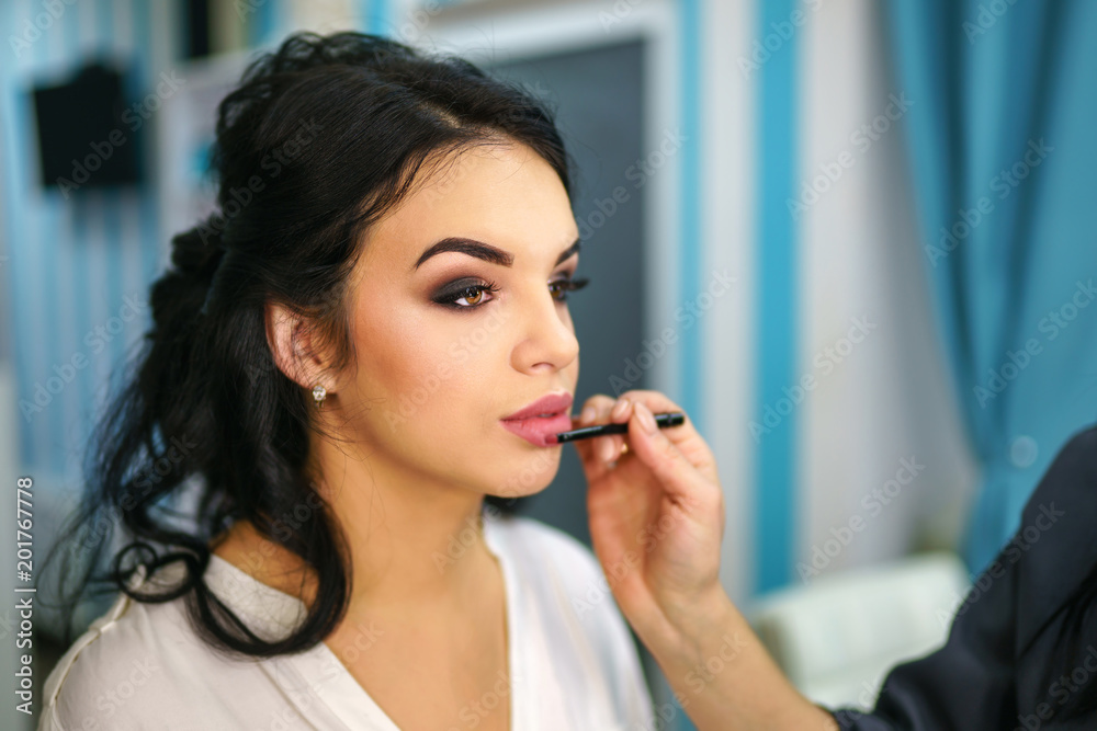 Pretty bride on the makeup before wedding ceremony