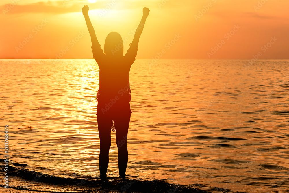 woman celebrated success with arm up at the beach