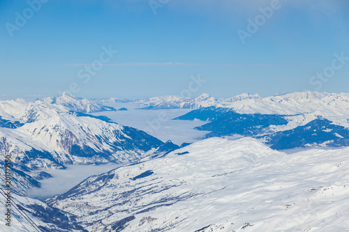 Aerial view to mountain valley with clouds at French alps. Mountain ski resort Three Valleys, France. © umike_foto