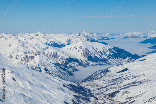 Aerial view to mountain valley with clouds at French alps. Mountain ski resort Three Valleys, France. © umike_foto