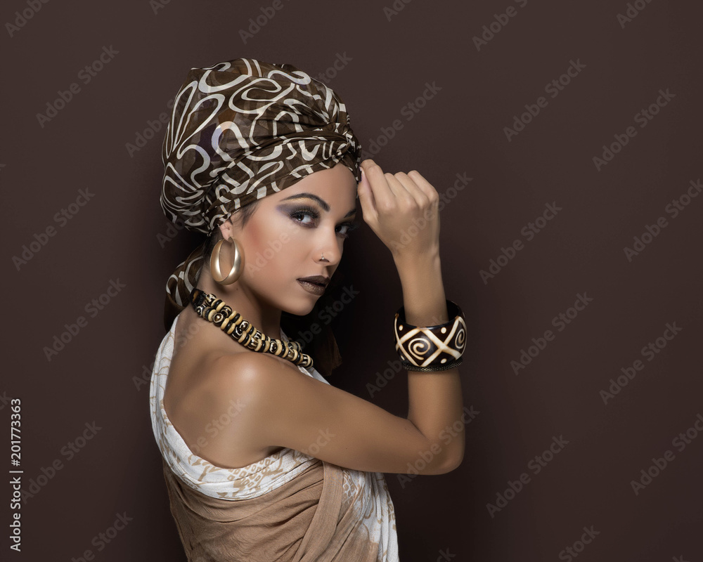 beauty girl with turban and brown makeup in front of a brown background with earrings beauty girl with turban and brown makeup in front of a brown background with earrings