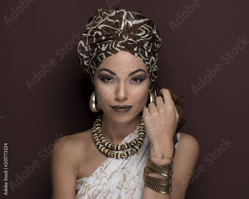 Fotografie, Obraz beauty girl with turban and brown makeup in front of a brown background with ear
