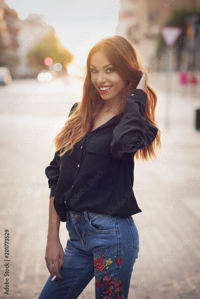 beauty girl dressed in denim and black shirt with orange hair in street