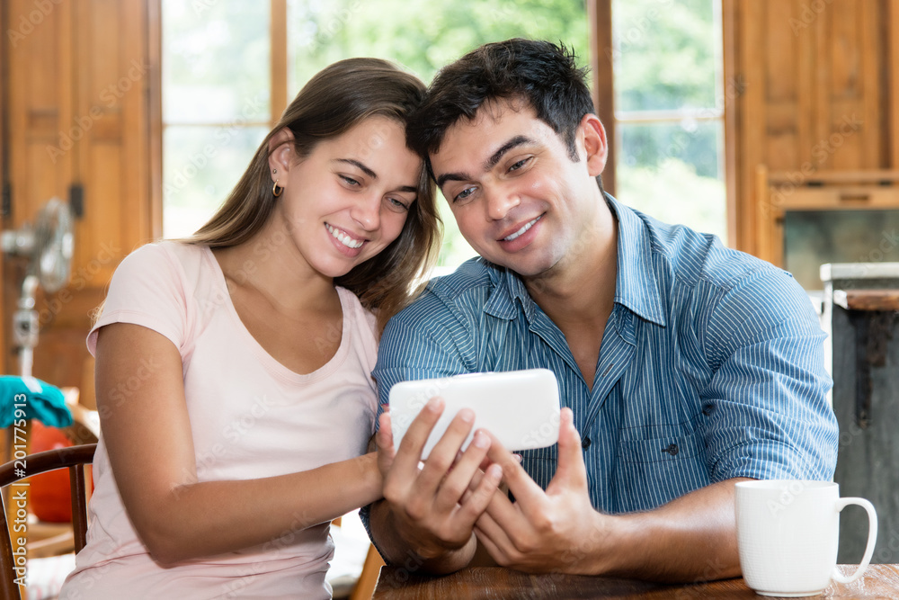 Caucasian love couple watching photos on cellphone