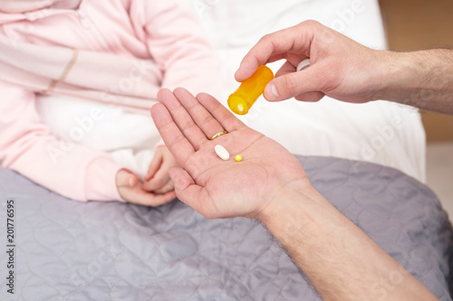 Best pills. Loving worried father holding pills and giving some to his ill daughter