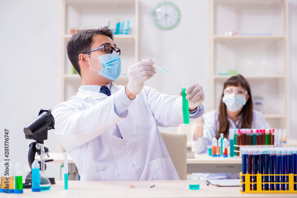 Two chemists working in lab experimenting Two chemists working in lab experimenting