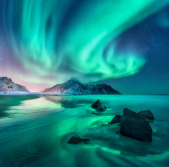 Gordijnen Koraalgroen Aurora. Northern lights in Lofoten islands, Norway. Sky with polar lights, stars. Night winter landscape with aurora, sea with sky reflection, stones, sandy beach and mountains. Green aurora borealis  © den-belitsky