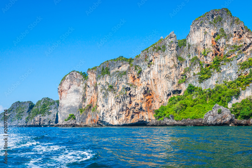 Cliff and the clear sea with a boat near Phi Phi island in south of Thailand