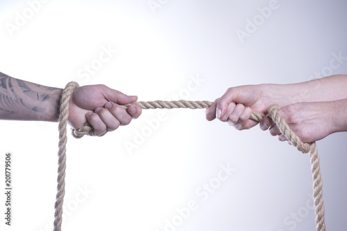 The hands of men and women pull rope on a white background.