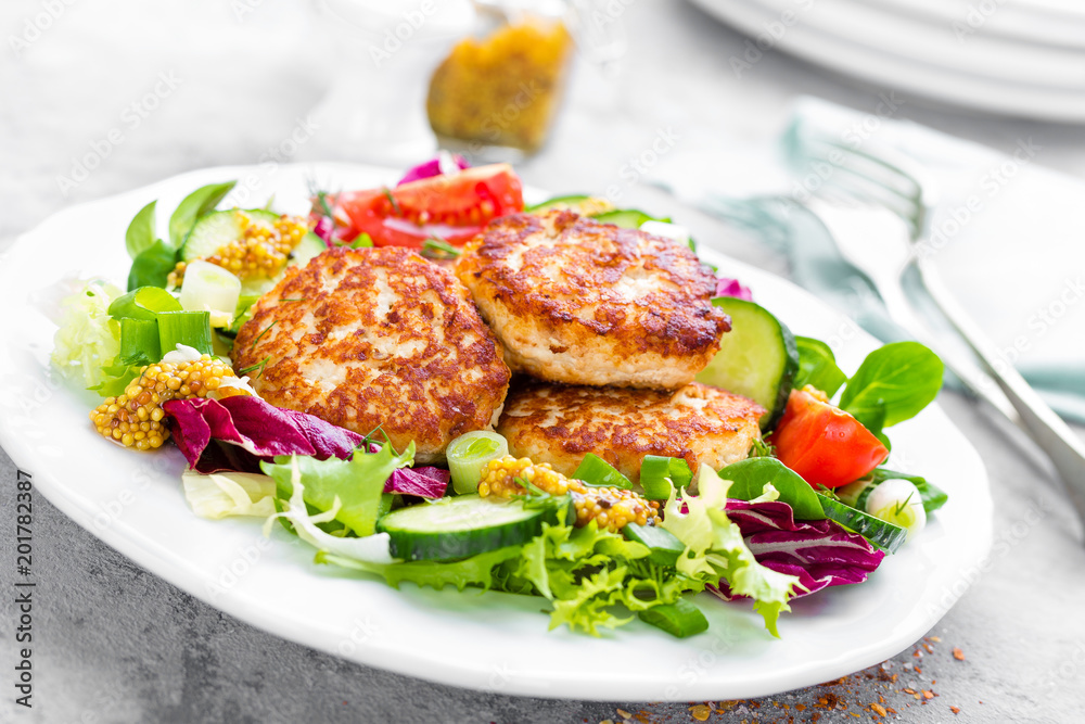 Cutlets and fresh vegetable salad on white plate. Fried meatballs with vegetable salad