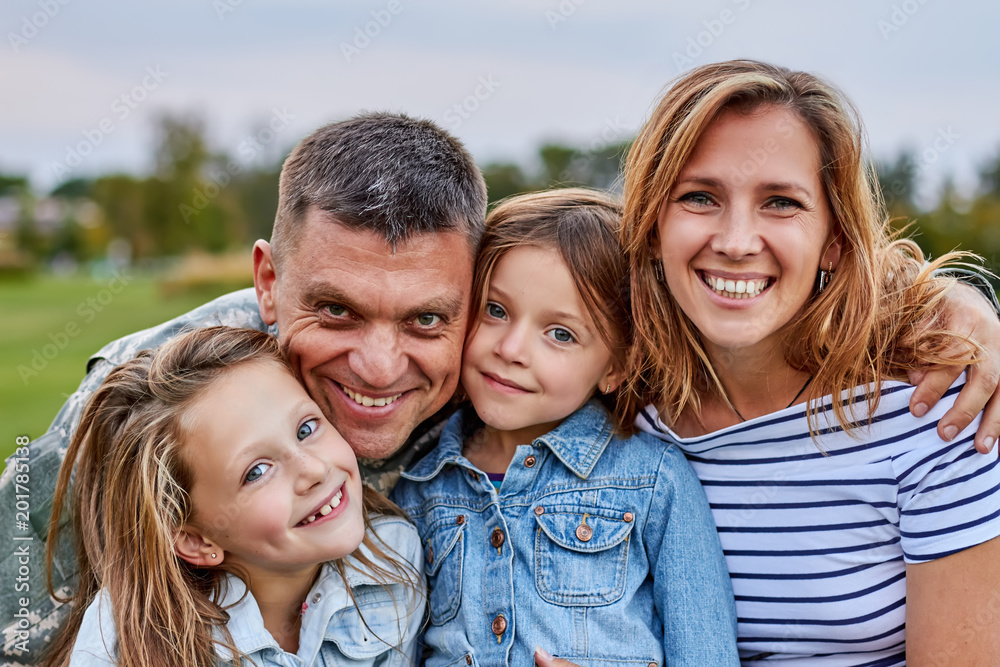 Portrait of happy family. Shot of smiling cheerful mature soldier with his family outdoor. Portrait of happy family. Shot of smiling cheerful mature soldier with his family outdoor.