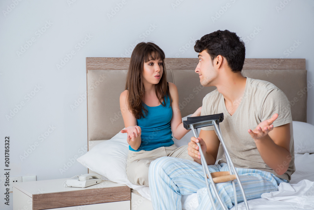 Obraz premium Young wife supporting husband on crutch after injury