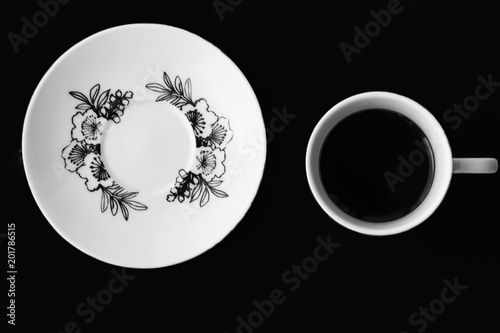 Cup and saucer on a black background stand separately photo