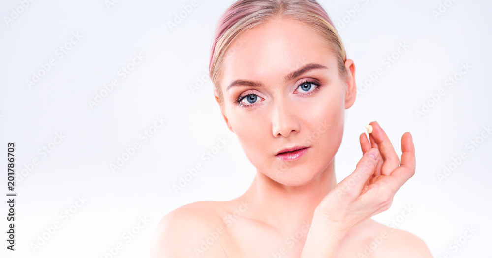 Portrait of happy smiling beautiful young woman touching skin or applying cream, isolated over white background Portrait of happy smiling beautiful young woman touching skin or applying cream, isolated over white background