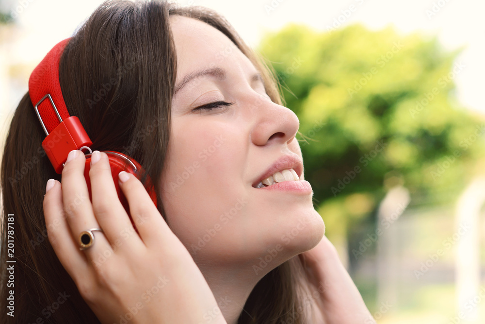 Young latin woman with headphones in a park. Young latin woman with headphones in a park.