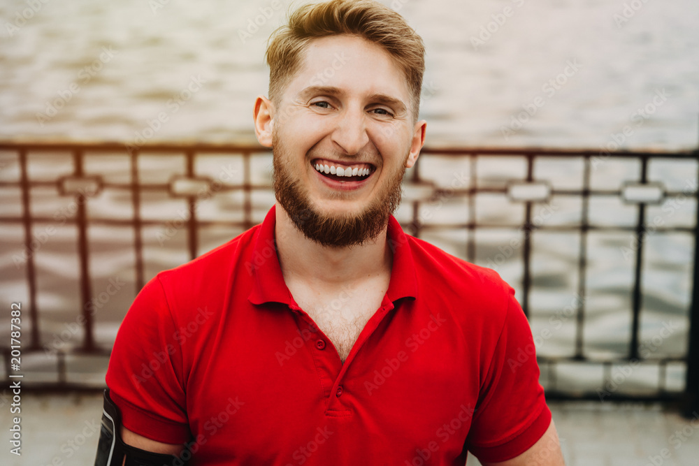 Obraz premium Close up portrait of running man with beard smiling and looking into camera.