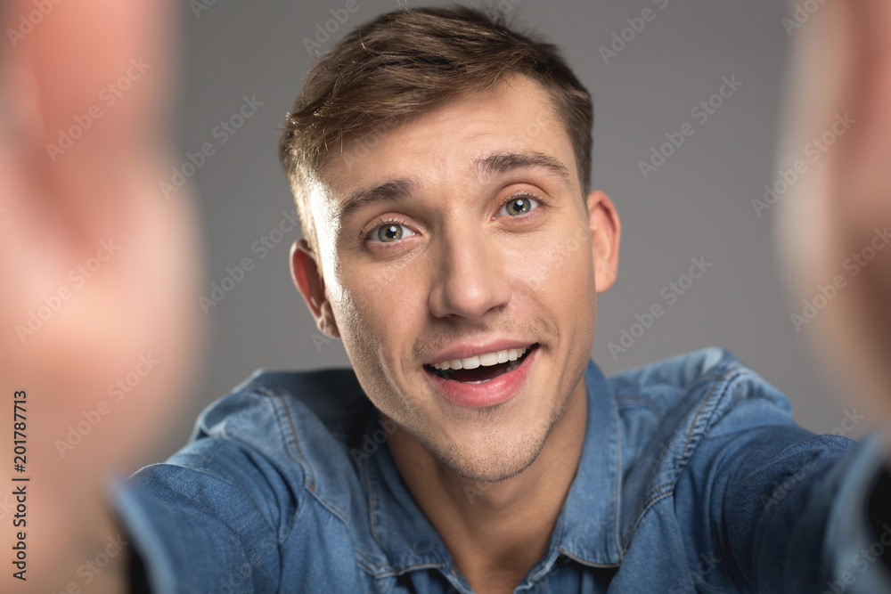 Portrait of glad male person reaching out his arms to camera. Isolated on background Portrait of glad male person reaching out his arms to camera. Isolated on background