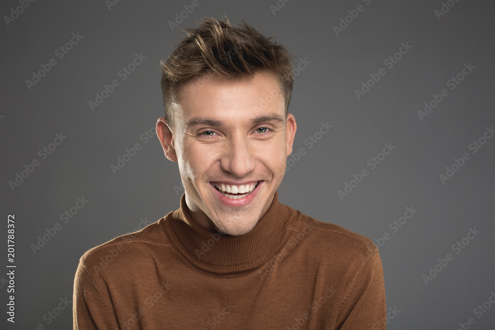 Portrait of cheerful man in pullover staring and laughing. Isolated on background Portrait of cheerful man in pullover staring and laughing. Isolated on background