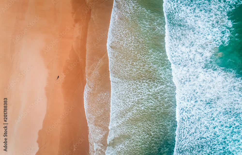 Aerial view of a man walking along a beach in Asturias - obrazy, fototapety, plakaty 