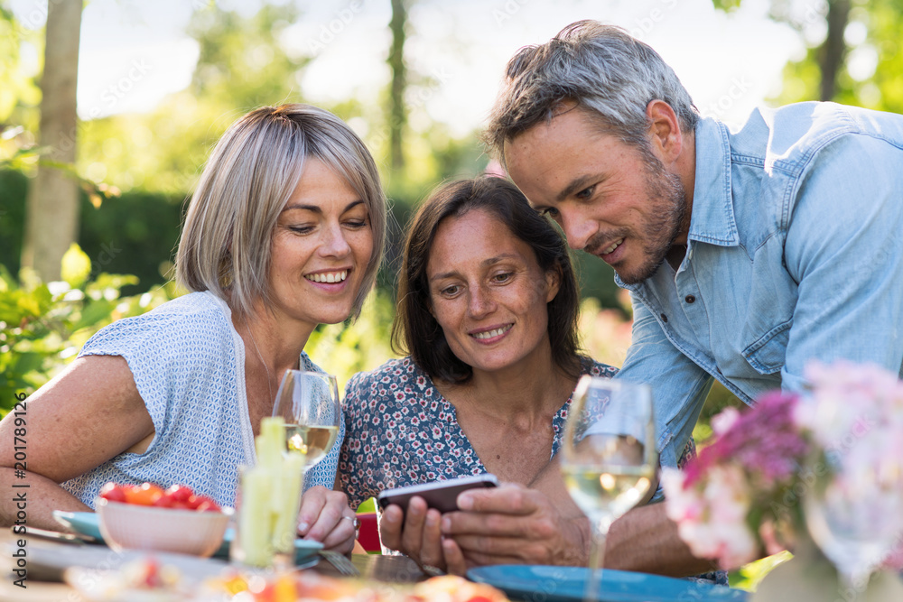 summer. Group of friends gathered around a table in the garden summer. Group of friends gathered around a table in the garden