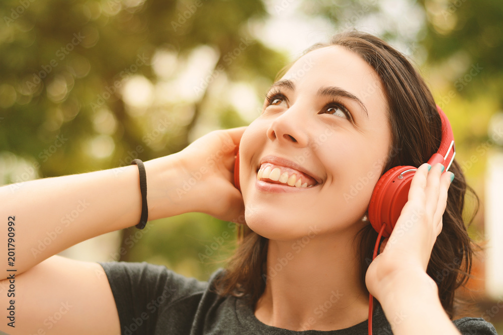 Portrait of young beautiful woman with red headphones listening music Portrait of young beautiful woman with red headphones listening music