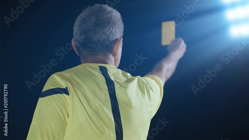 Football soccer referee shows penalty yellow card