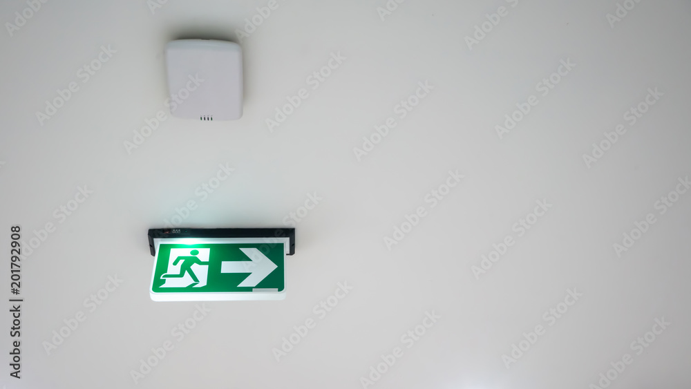 Green emergency exit sign. Direction to the escape way on white background. Green emergency exit sign. Direction to the escape way on white background.