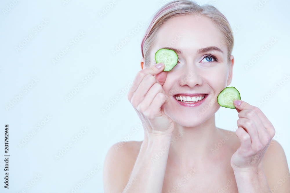 Young beautiful woman with cucumber slices on white background Young beautiful woman with cucumber slices on white background
