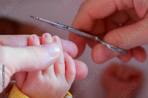 Cutting nails to a newborn baby a little mother care