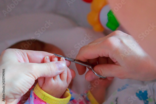 Cutting nails to a newborn baby a little mother care