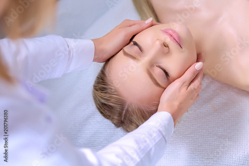 Young woman lying on a massage table,relaxing with eyes closed. Woman. Spa salon