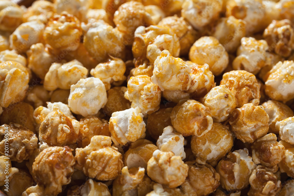 Golden caramel popcorn closeup. Background of popcorn. Snacks and food for a movie Golden caramel popcorn closeup. Background of popcorn. Snacks and food for a movie