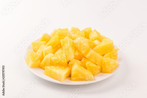 Pineapple slice on white plate on white background.