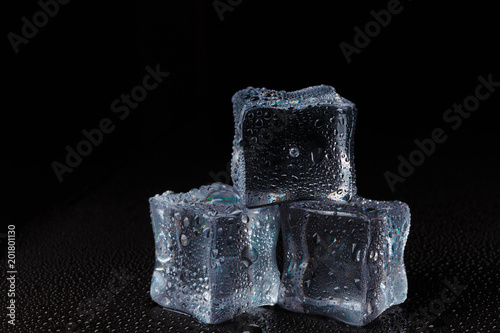 Fototapeta Naklejka Na Ścianę i Meble -  Cubes of clear ice on a black table.