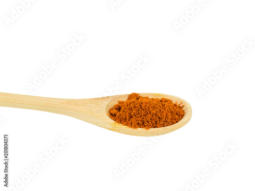 Light wood spoon with ground red pepper isolated on white background.