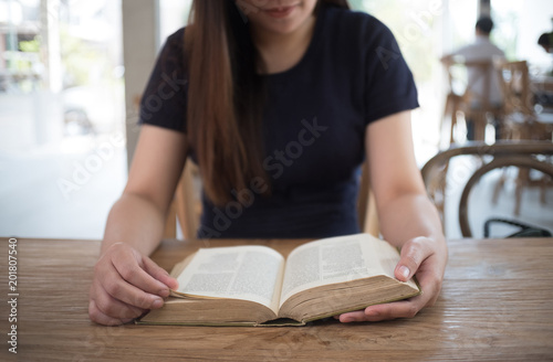 beautiful girl happy to sit reading a book Close-up of female relaxing in coffee shop cup of tea © onephoto