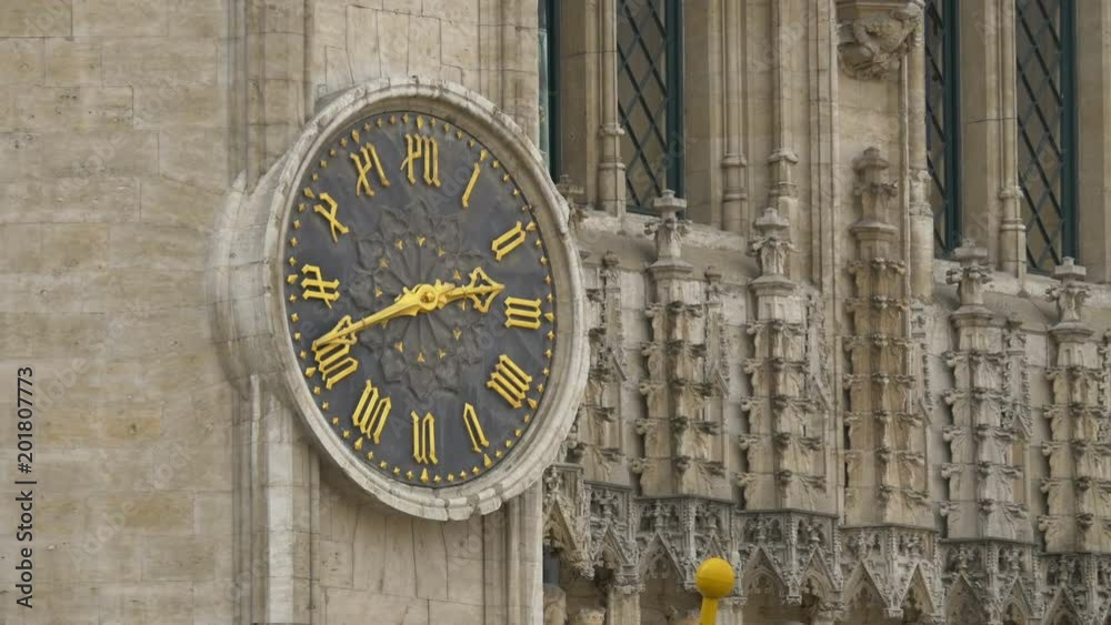 A clock with golden numbers on a building A clock with golden numbers on a building