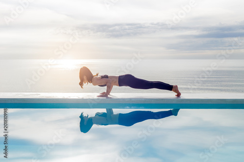 Asian young woman practice yoga Plank or Phalakasana Pose on the beach with beautiful sea,Feeling so comfortable and relax in holiday
