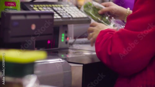 Close up check out counter. Hands of woman working on cash register in the supermarket